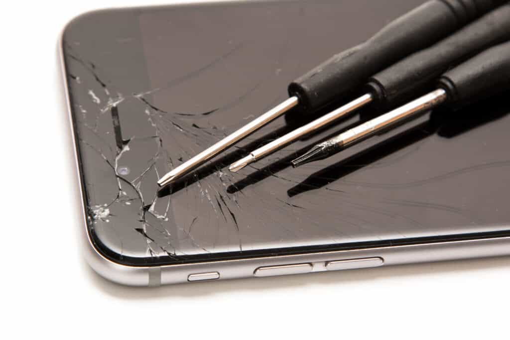 iPhone cassé et petits tournevis pour la réparation